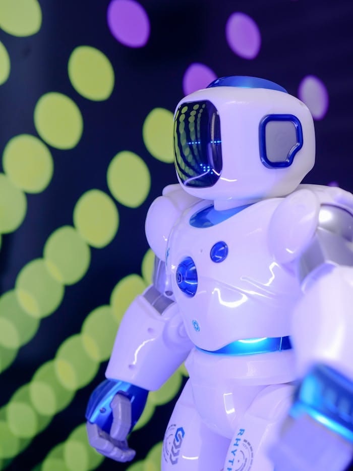 services-03 Close-up of a futuristic robot with glowing lights and a high-tech design in vibrant background.